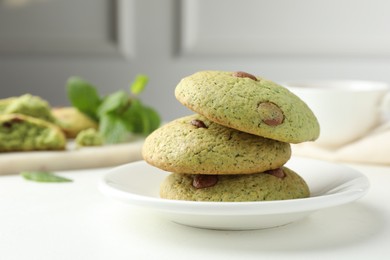 Photo of Delicious mint chocolate chip cookies on white table, closeup