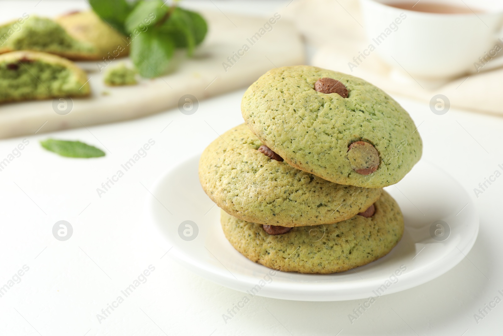 Photo of Delicious mint chocolate chip cookies on white table, closeup