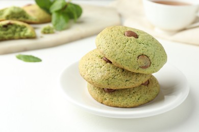 Photo of Delicious mint chocolate chip cookies on white table, closeup