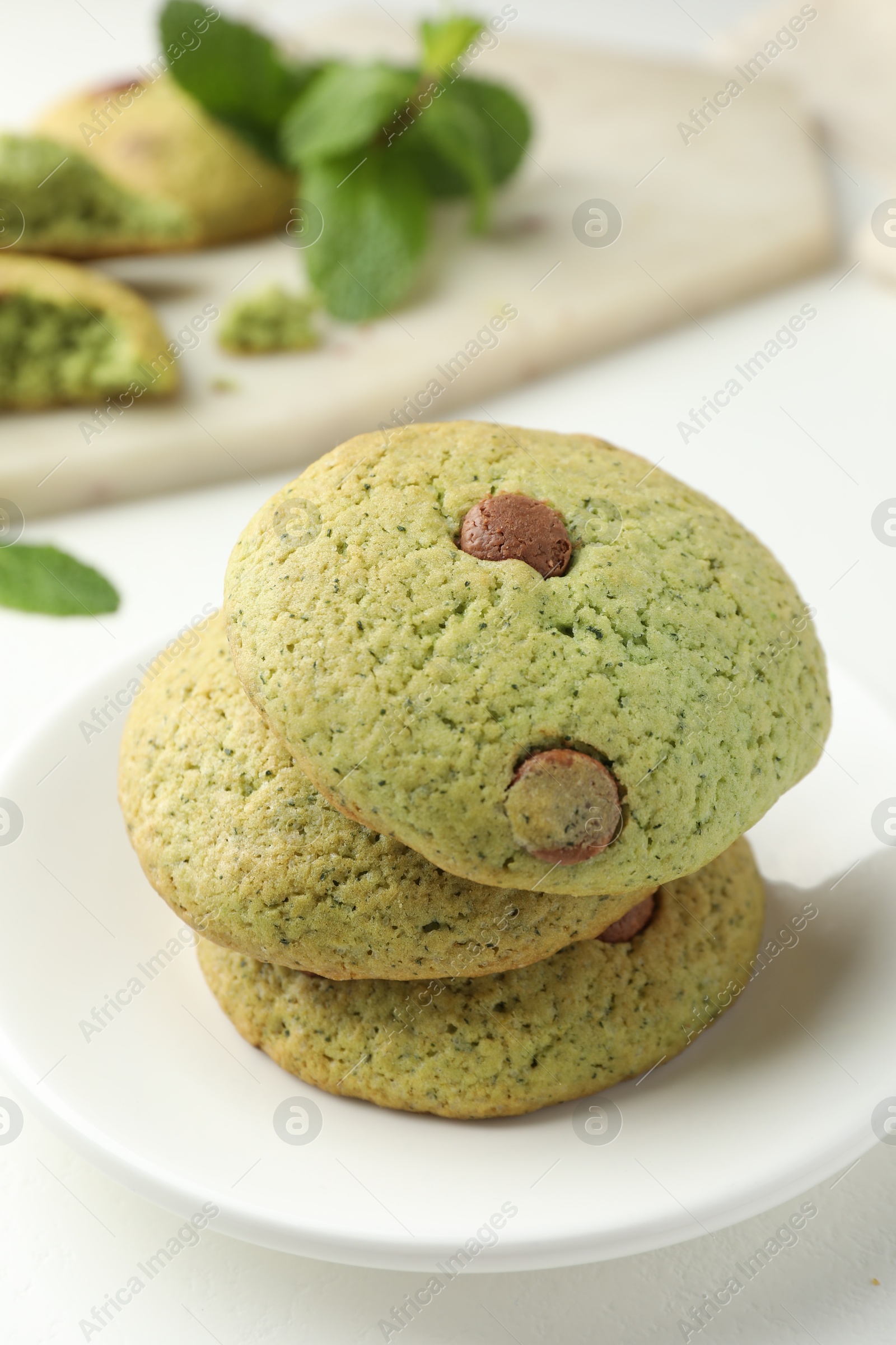 Photo of Delicious mint chocolate chip cookies on white table, closeup