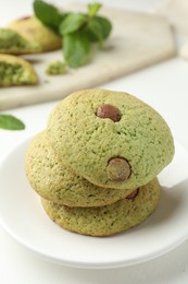 Photo of Delicious mint chocolate chip cookies on white table, closeup