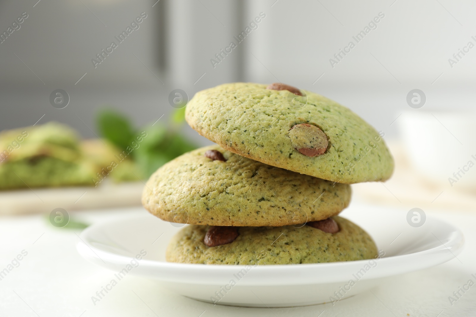 Photo of Delicious mint chocolate chip cookies on white table, closeup