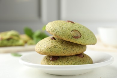 Photo of Delicious mint chocolate chip cookies on white table, closeup