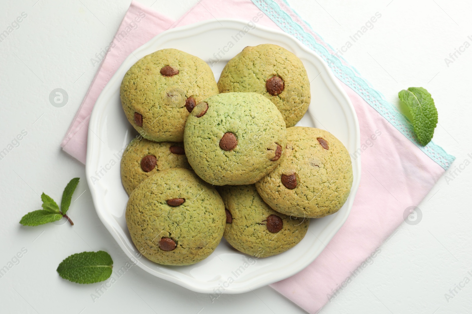 Photo of Delicious mint chocolate chip cookies on white table, top view