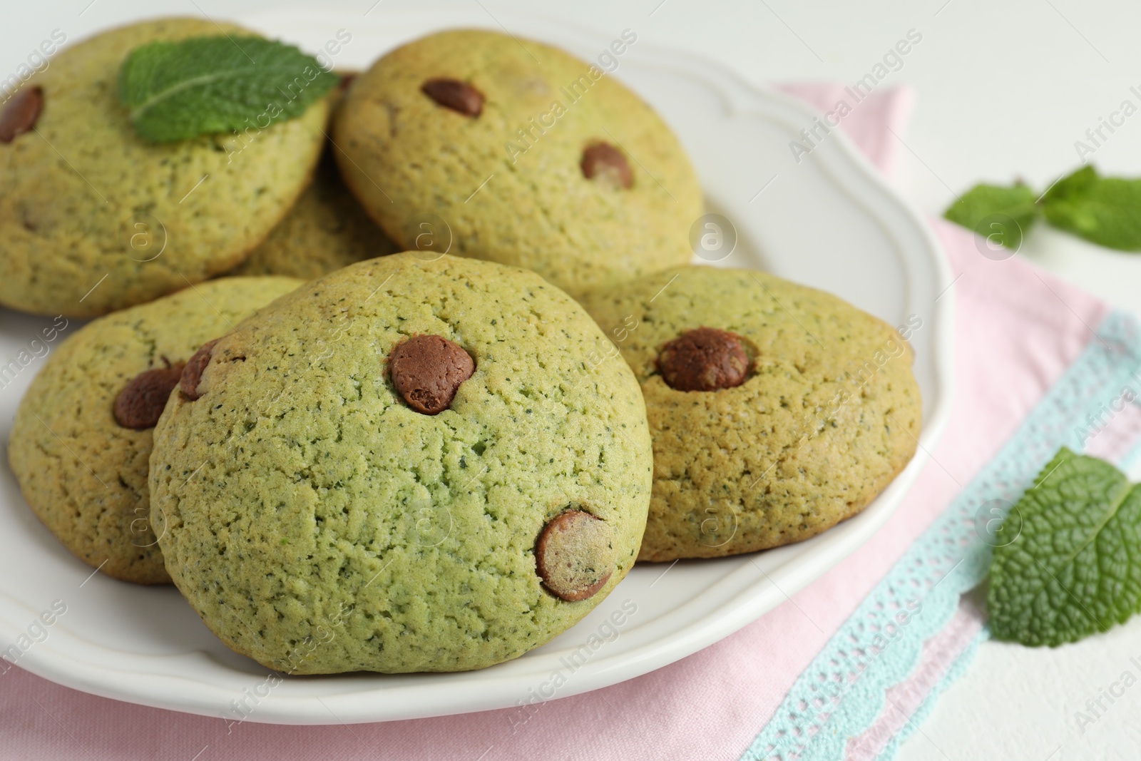 Photo of Delicious mint chocolate chip cookies on table, closeup