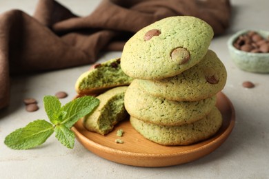 Photo of Delicious mint chocolate chip cookies on light table, closeup