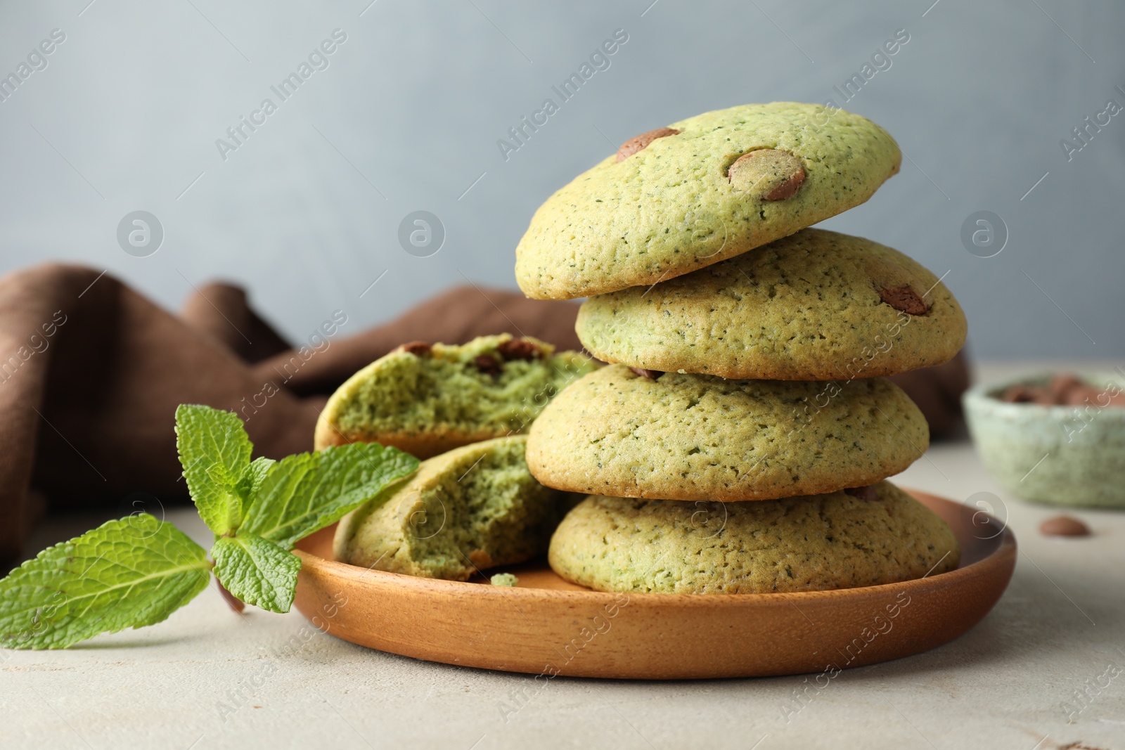 Photo of Delicious mint chocolate chip cookies on light table, closeup