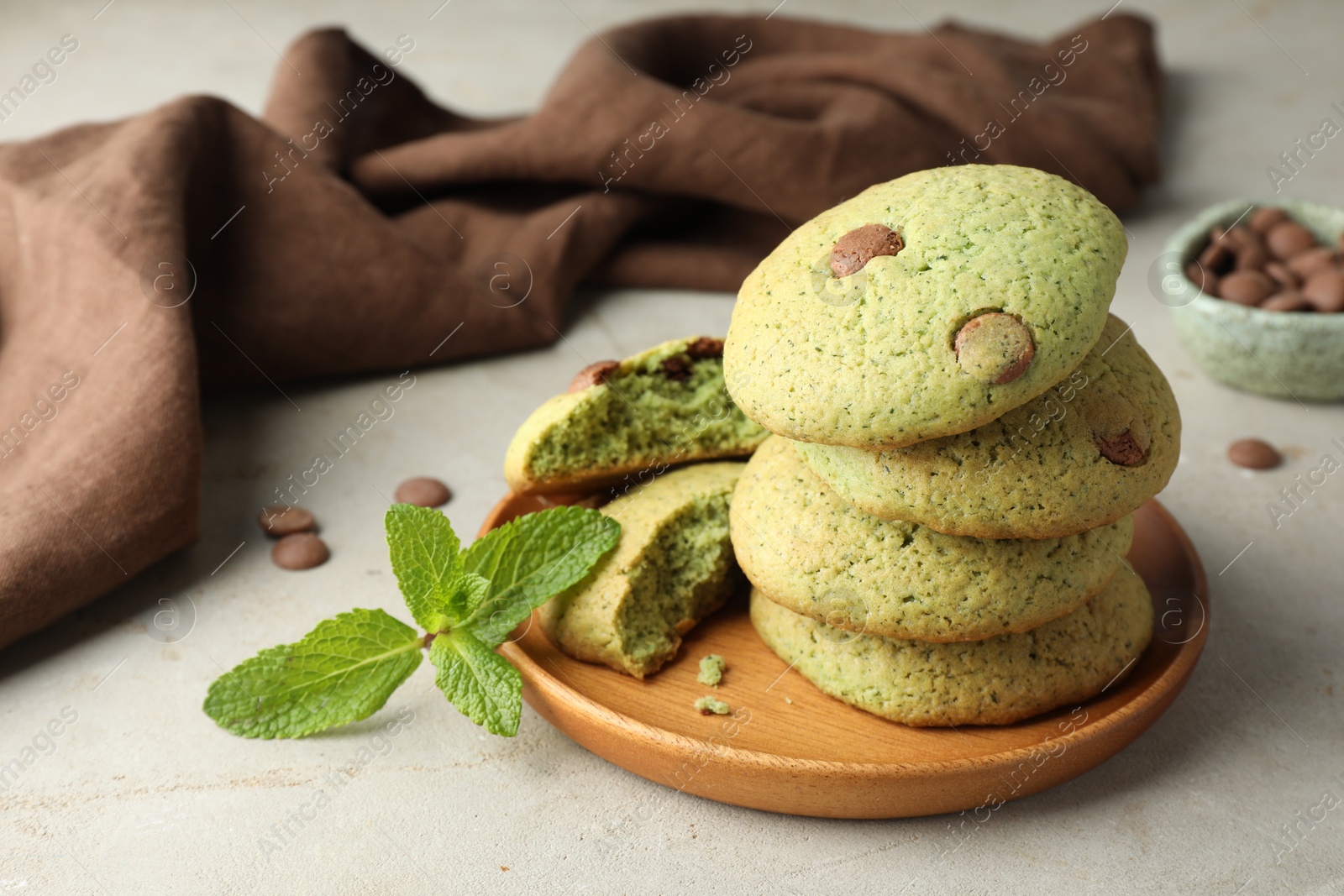 Photo of Delicious mint chocolate chip cookies on light table, closeup