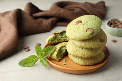 Photo of Delicious mint chocolate chip cookies on light table, closeup