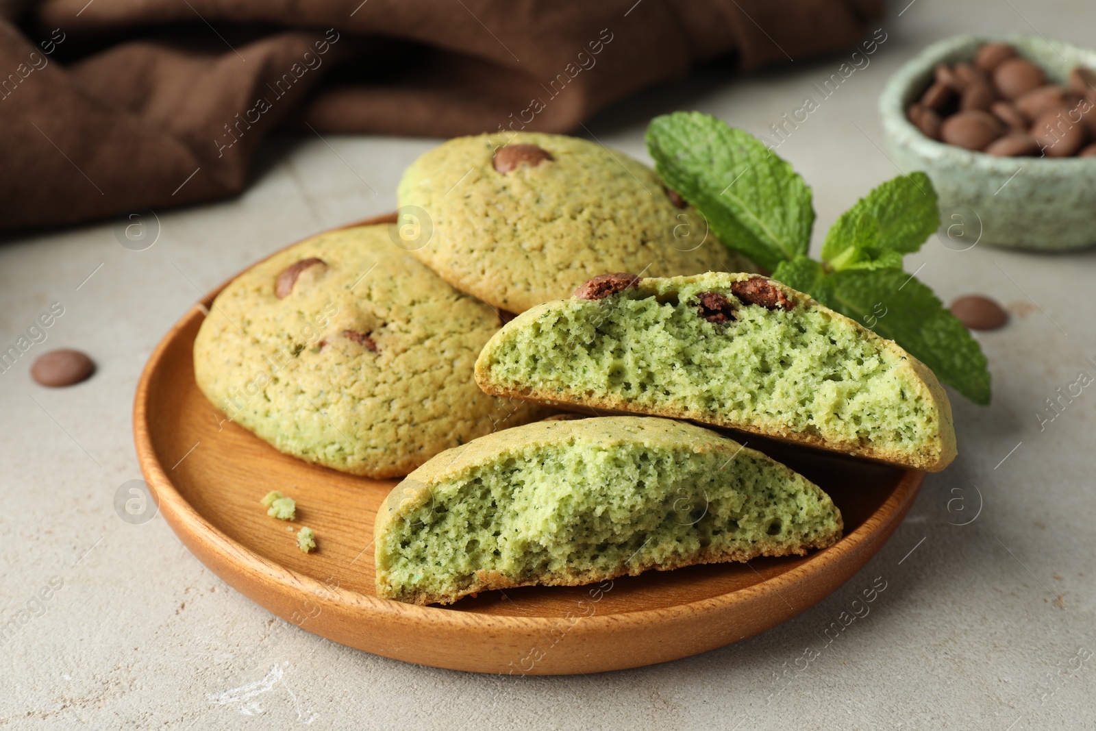 Photo of Delicious mint chocolate chip cookies on light table, closeup