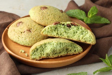 Photo of Delicious mint chocolate chip cookies on light table, closeup