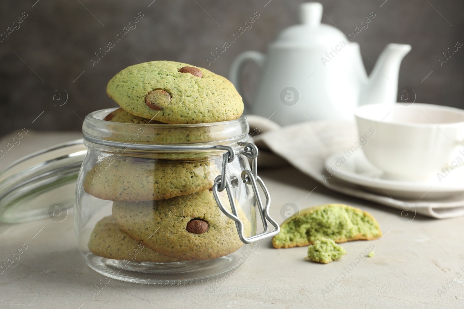 Photo of Delicious mint chocolate chip cookies in jar on light table, closeup