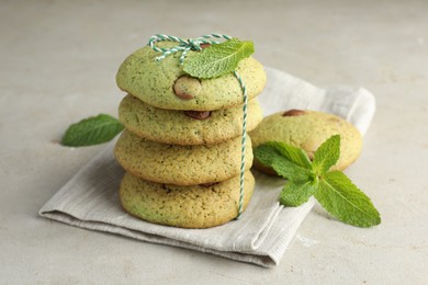 Photo of Delicious mint chocolate chip cookies on light table, closeup