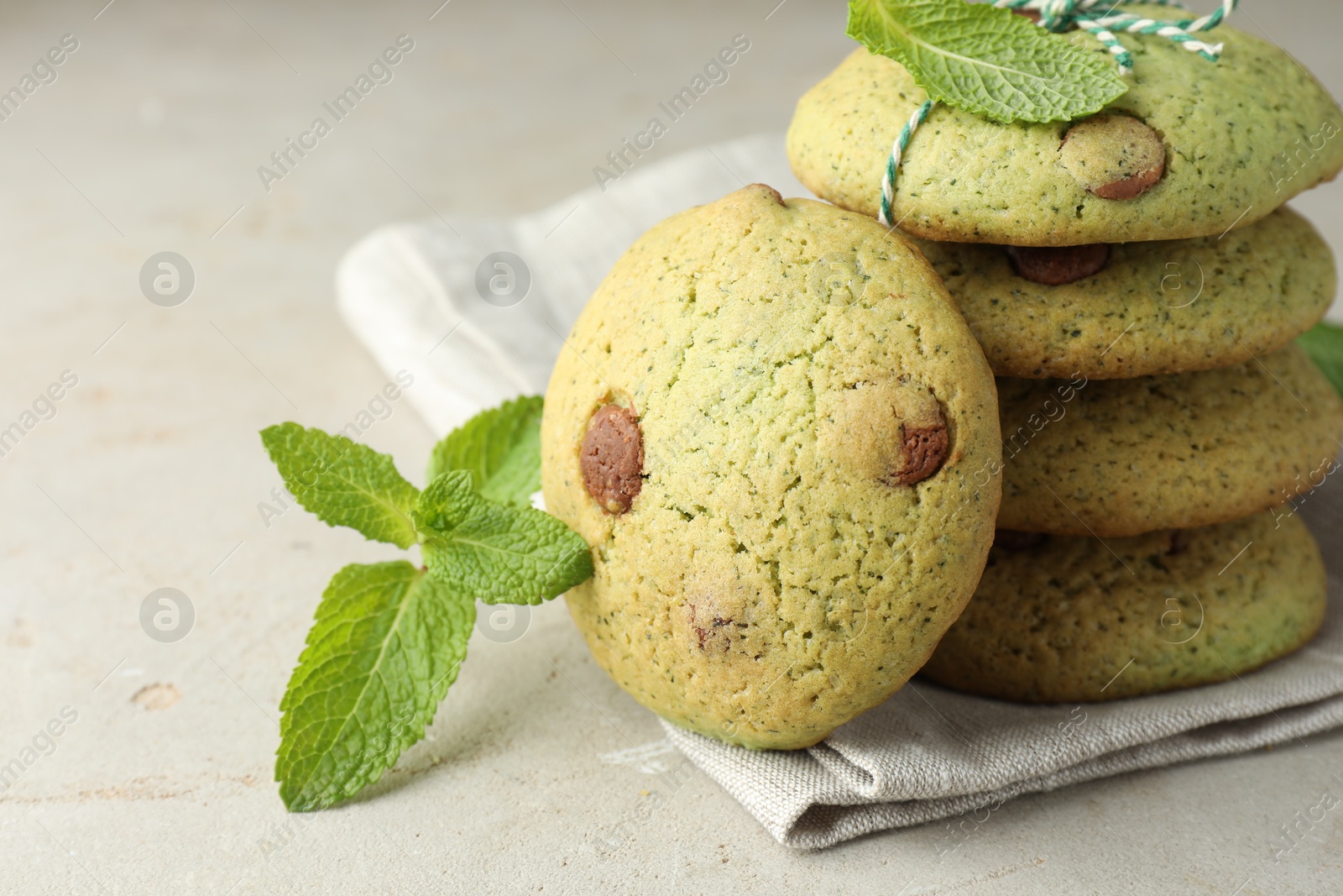 Photo of Delicious mint chocolate chip cookies on light table, closeup