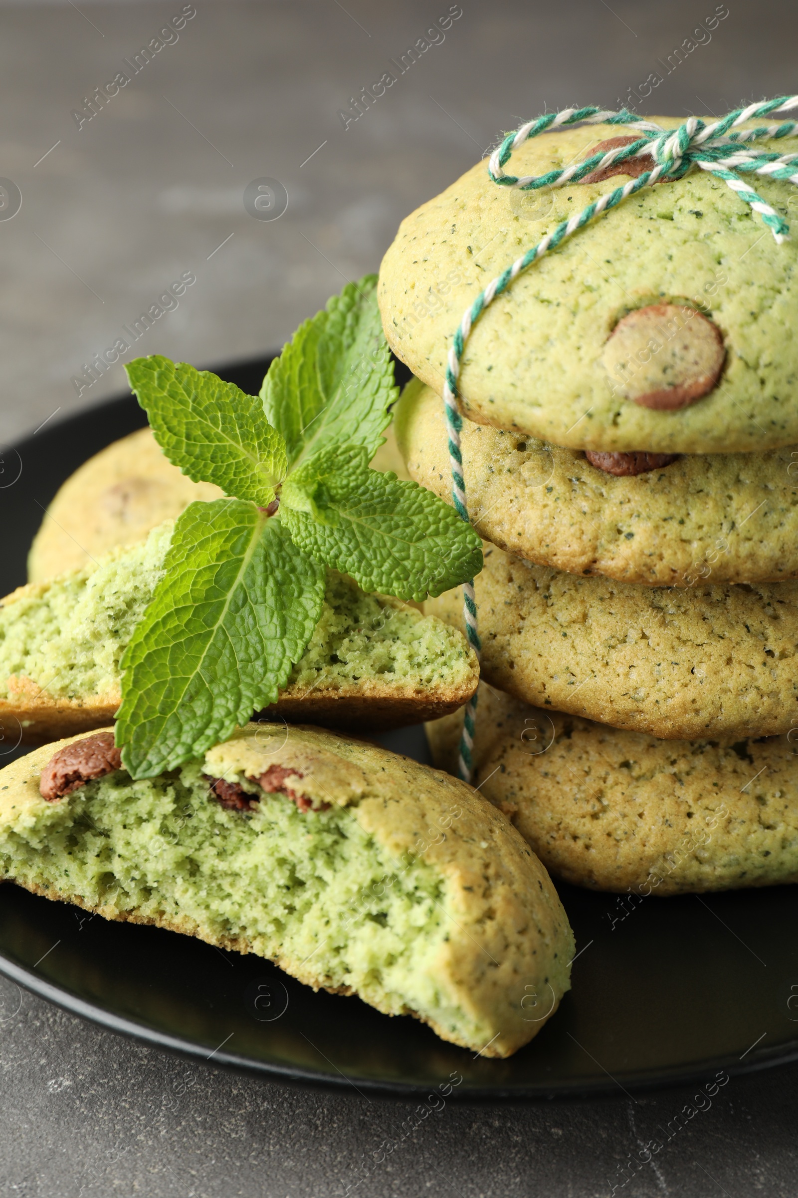 Photo of Delicious mint chocolate chip cookies on grey table, closeup