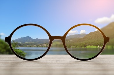 Image of Glasses against beautiful landscape. View through lenses more clear. Vision correction