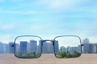 Glasses against cityscape. View through lenses more clear. Vision correction