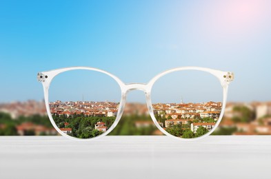 Image of Glasses against cityscape. View through lenses more clear. Vision correction