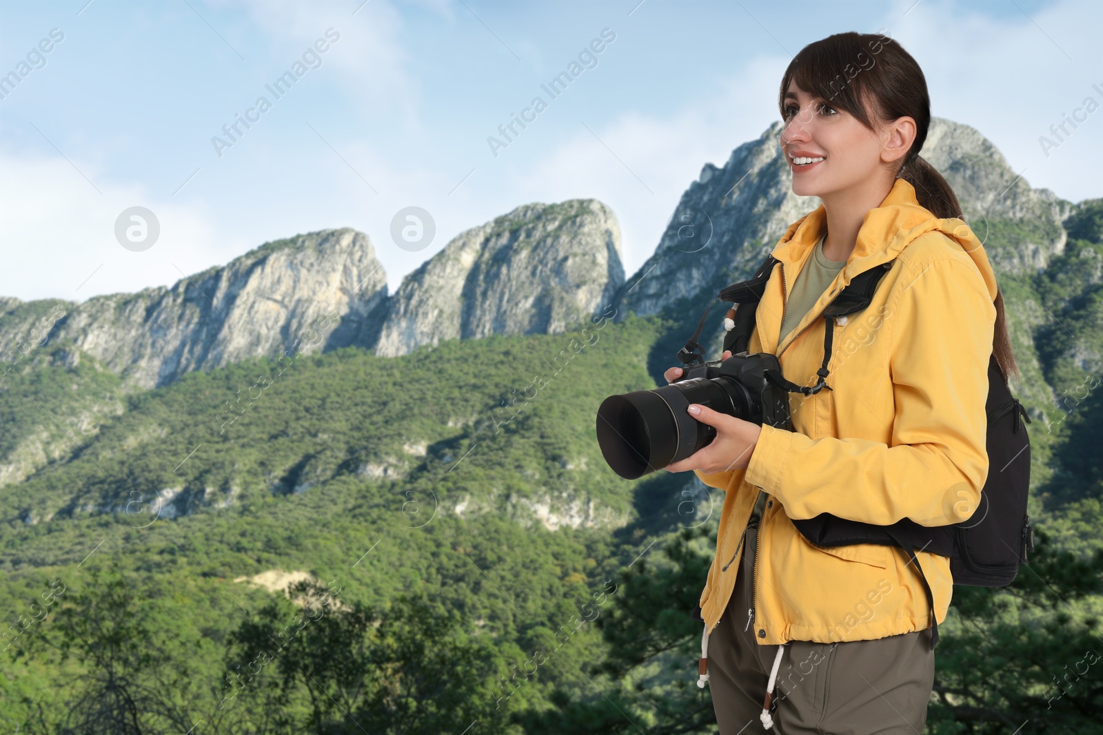 Image of Photographer with camera and backpack in mountains