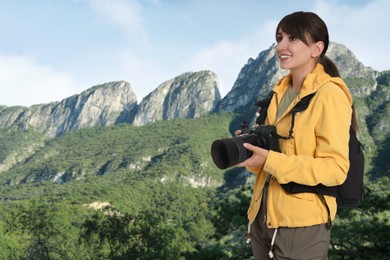 Image of Photographer with camera and backpack in mountains