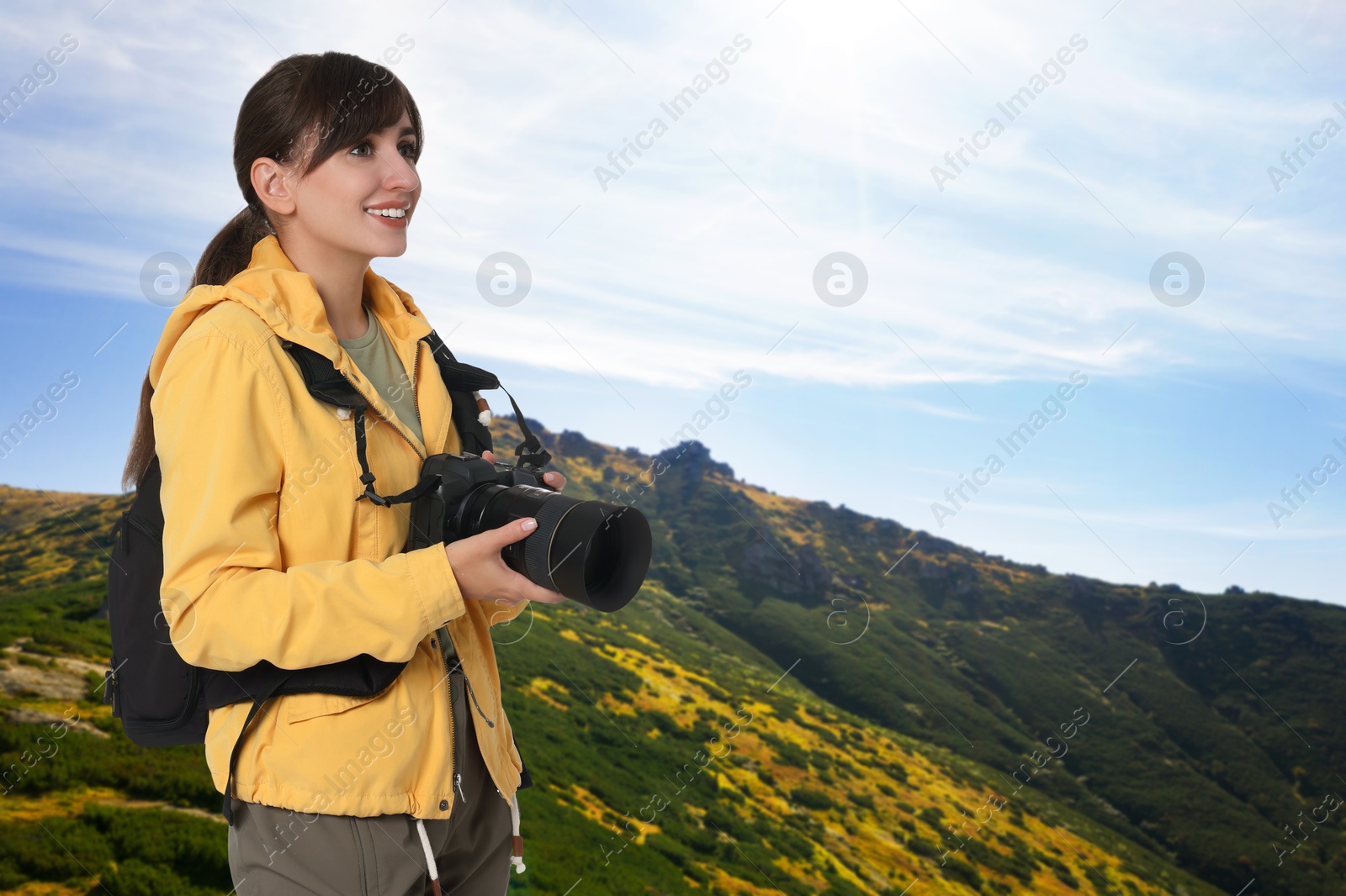 Image of Photographer with camera and backpack in mountains