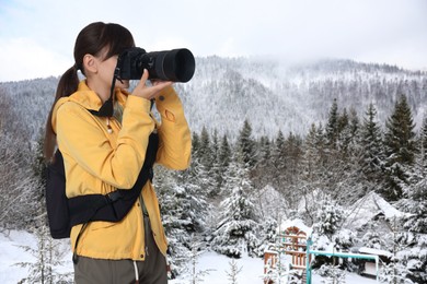 Image of Woman with backpack taking photo in mountains