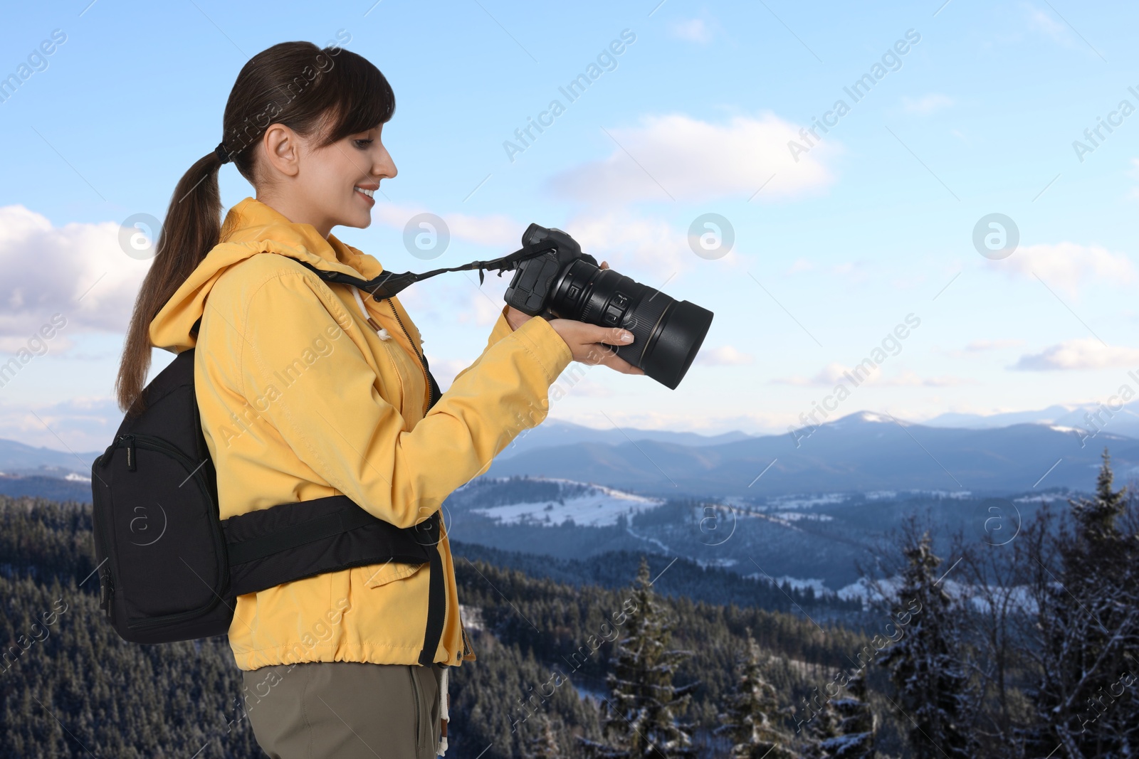 Image of Photographer with camera and backpack in mountains