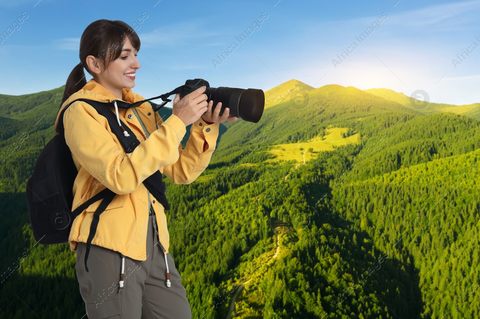 Image of Photographer with camera and backpack in mountains