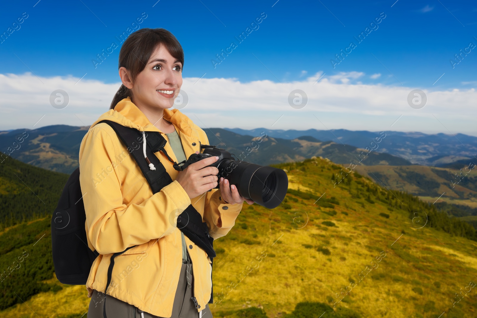 Image of Photographer with camera and backpack in mountains