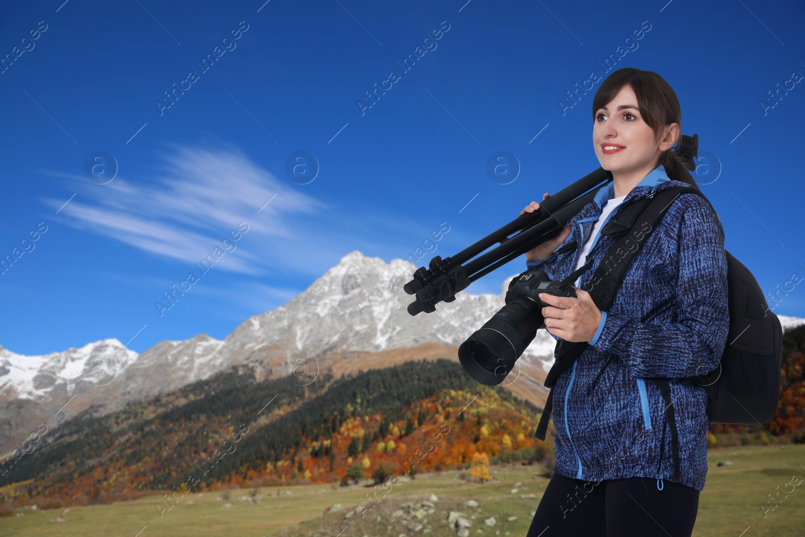 Image of Woman with photography equipment and backpack in mountains