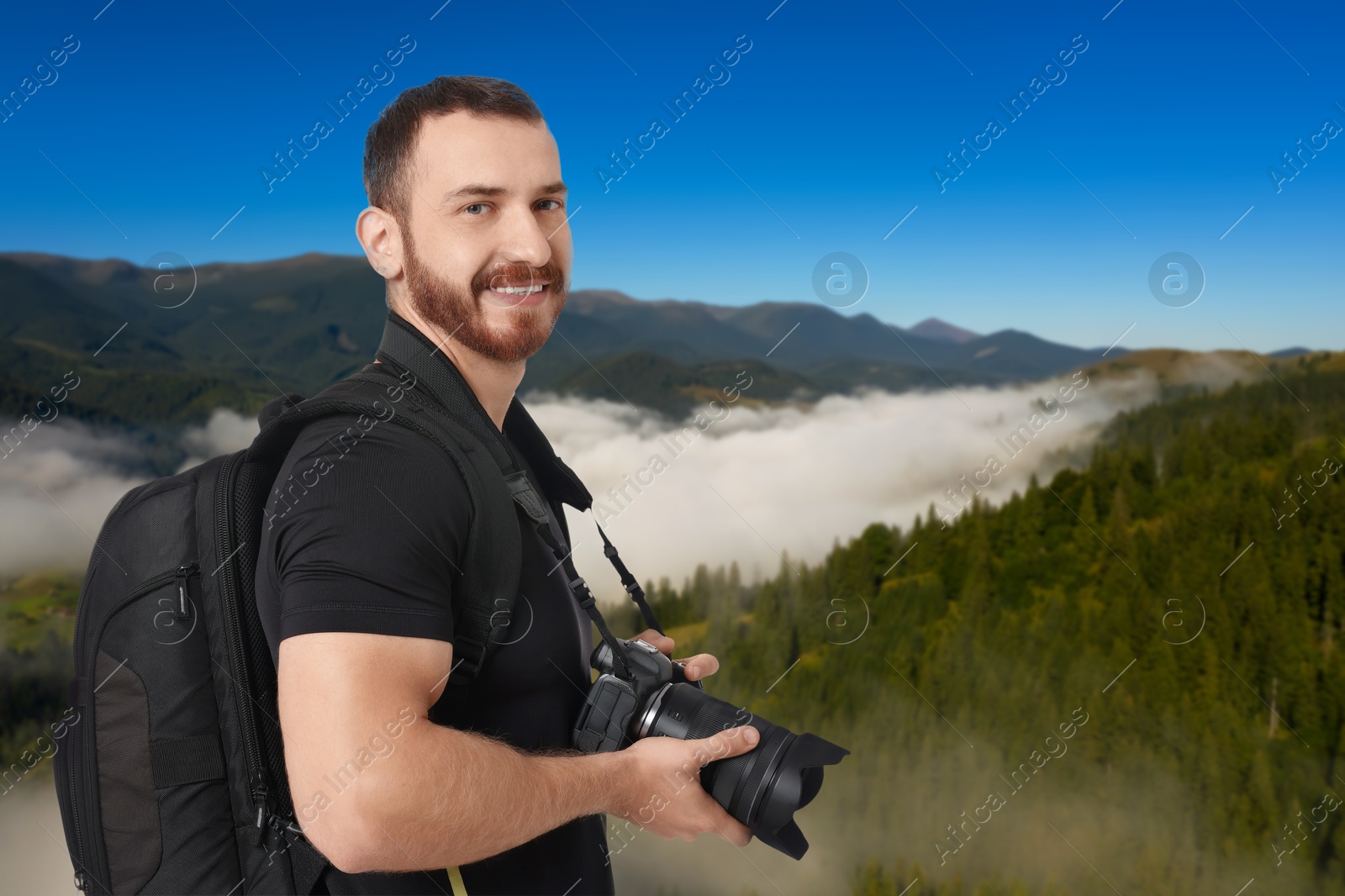 Image of Photographer with camera and backpack in mountains