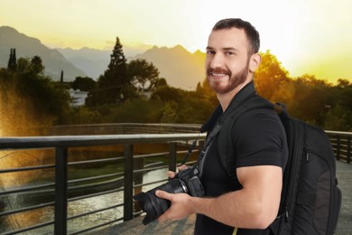 Image of Photographer with backpack and camera on bridge