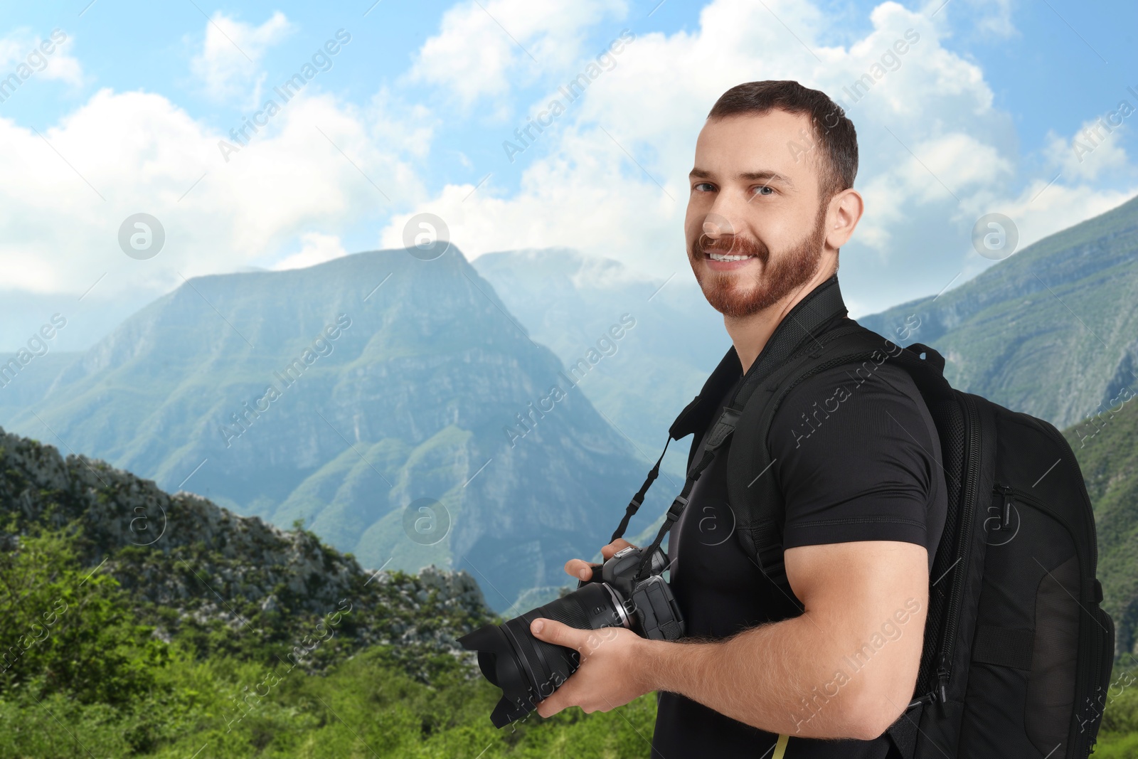 Image of Photographer with camera and backpack in mountains