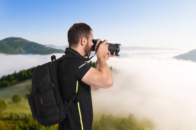 Man with backpack taking photo in mountains