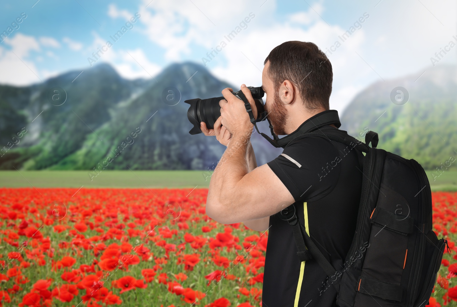 Image of Man with backpack taking photo in mountains