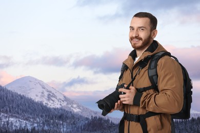 Photographer with camera and backpack in mountains