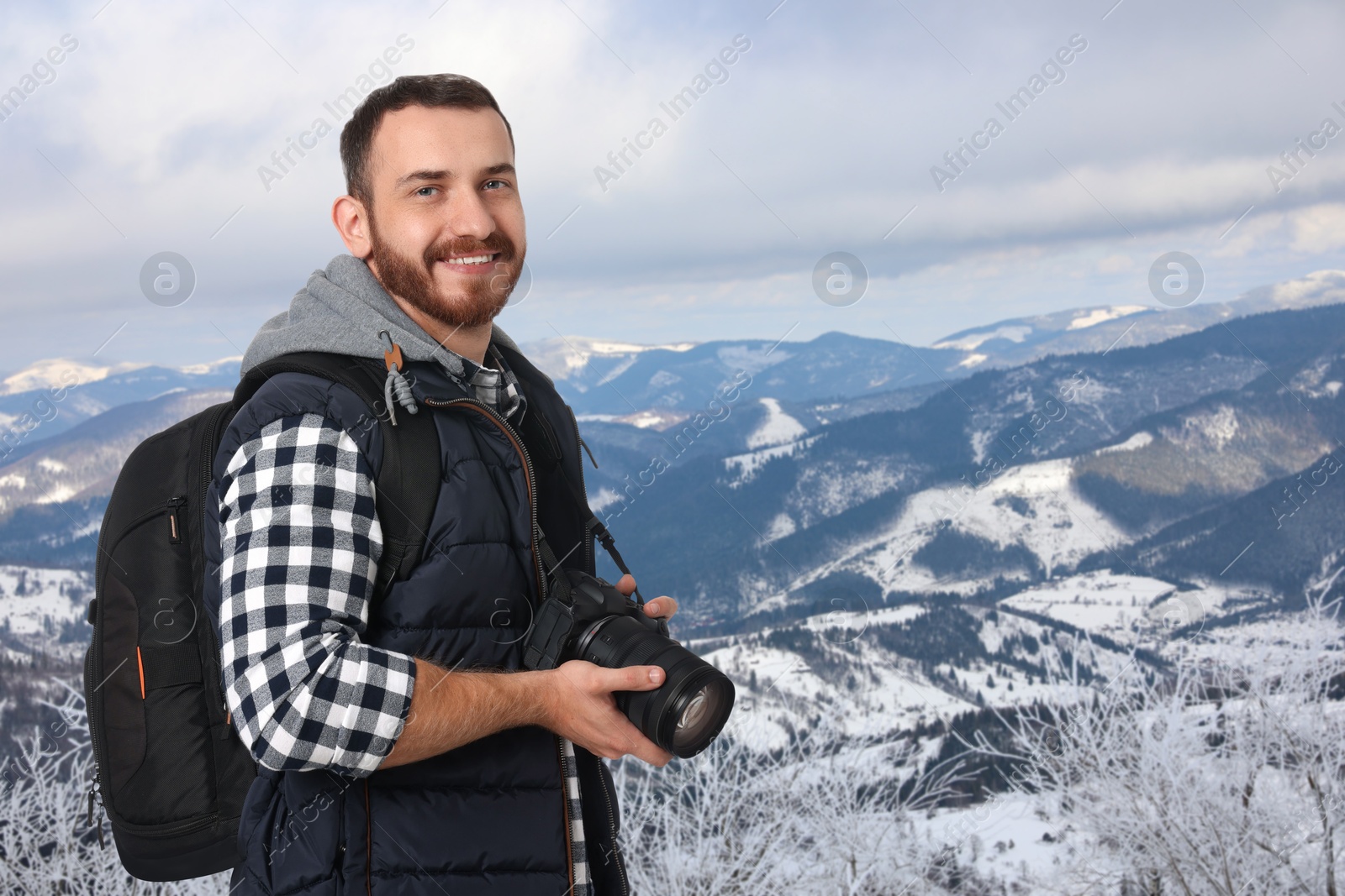 Image of Photographer with camera and backpack in mountains