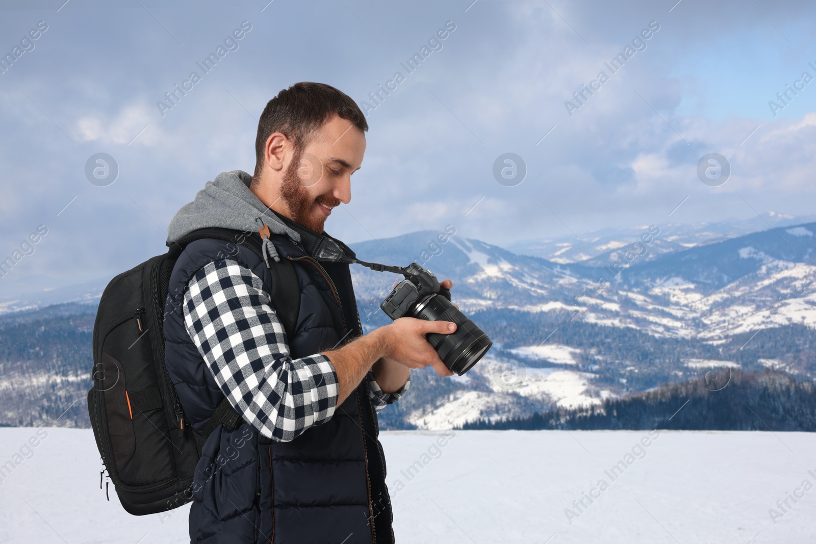 Image of Photographer with camera and backpack in mountains