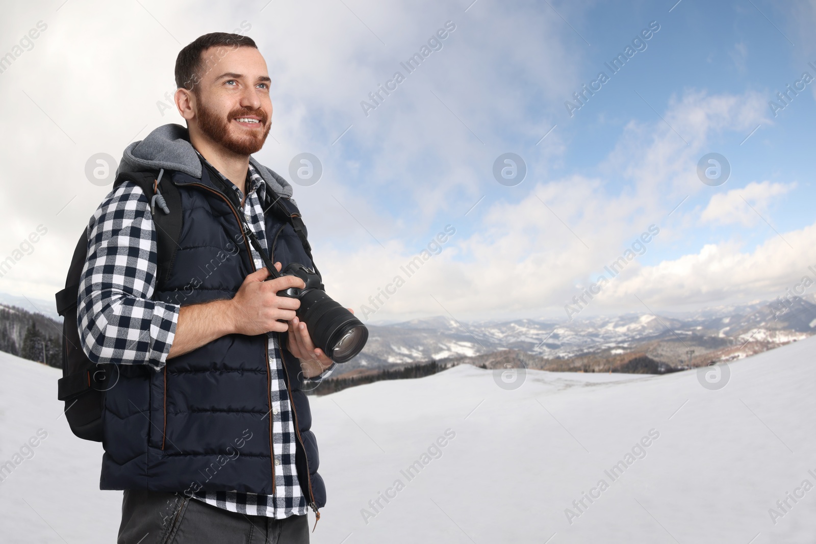 Image of Photographer with camera and backpack in mountains