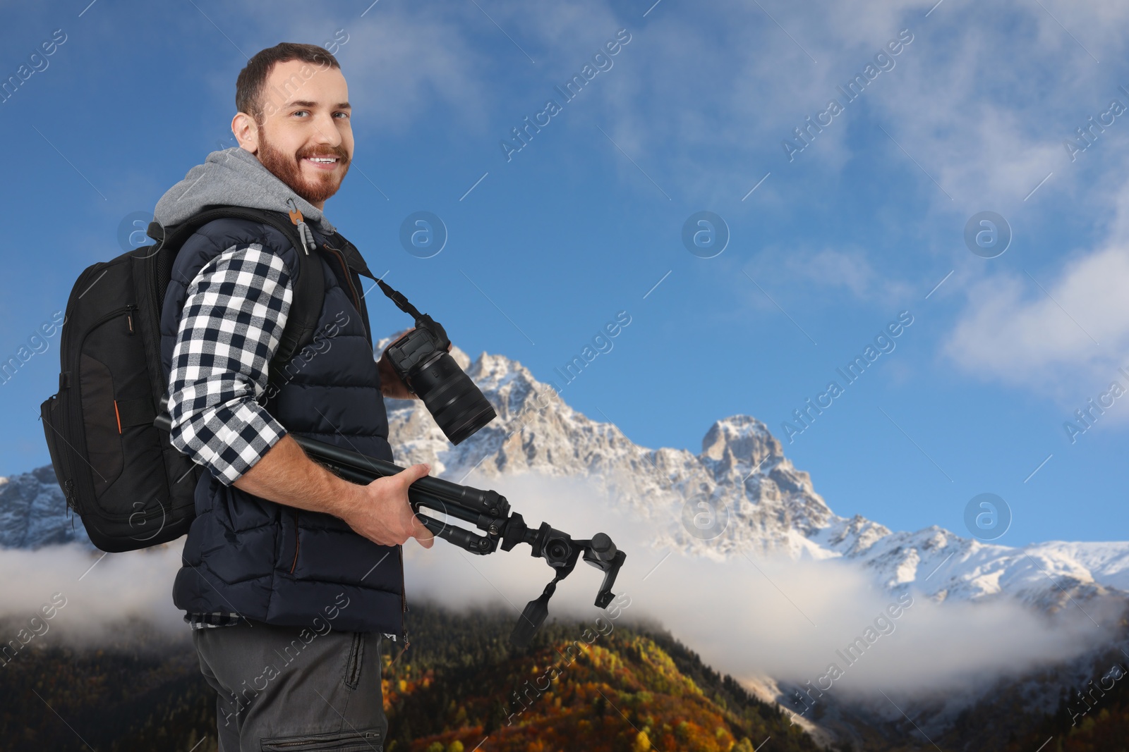 Image of Man with backpack and [photography equipment in mountains