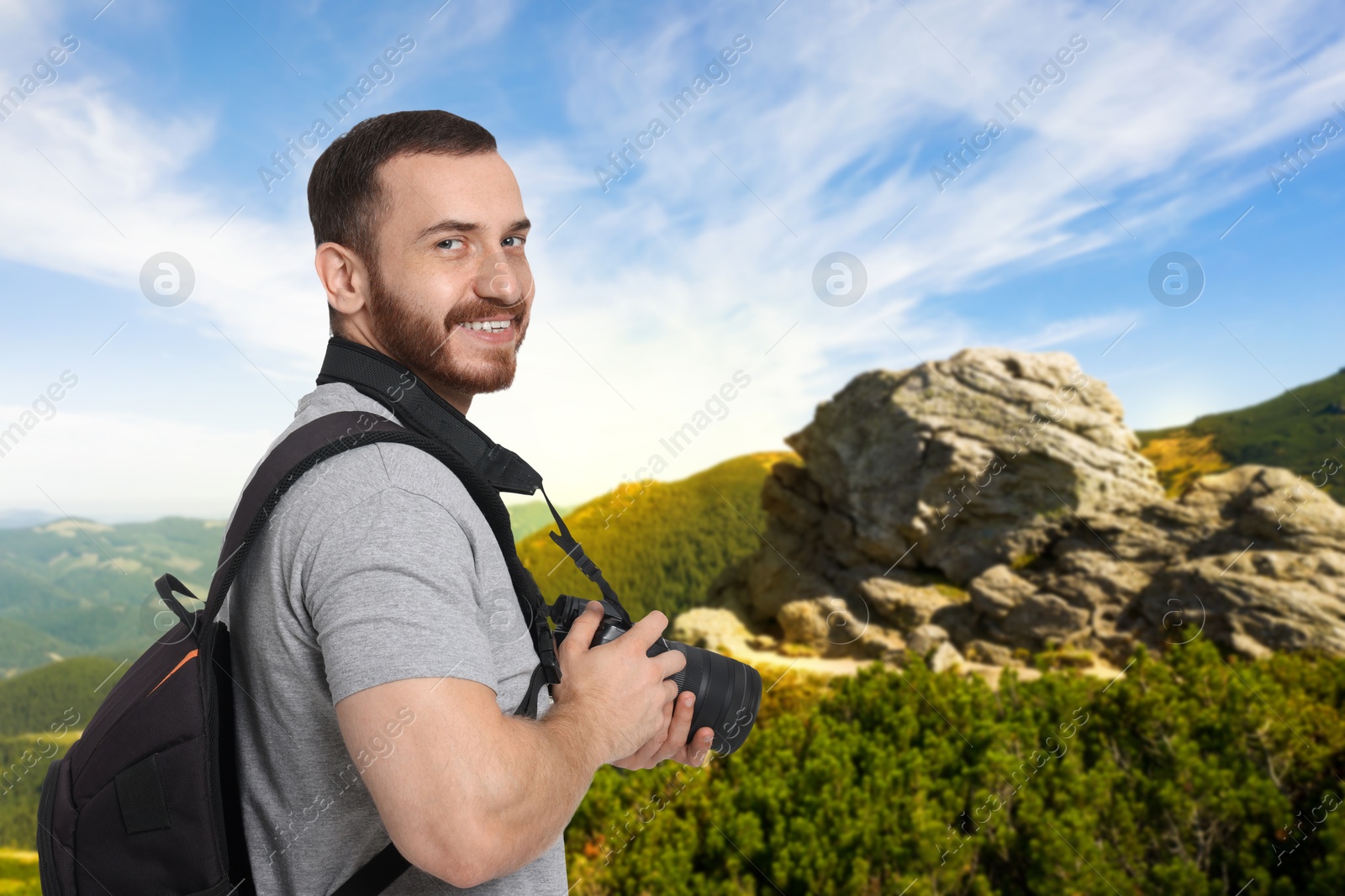 Image of Photographer with camera and backpack in mountains