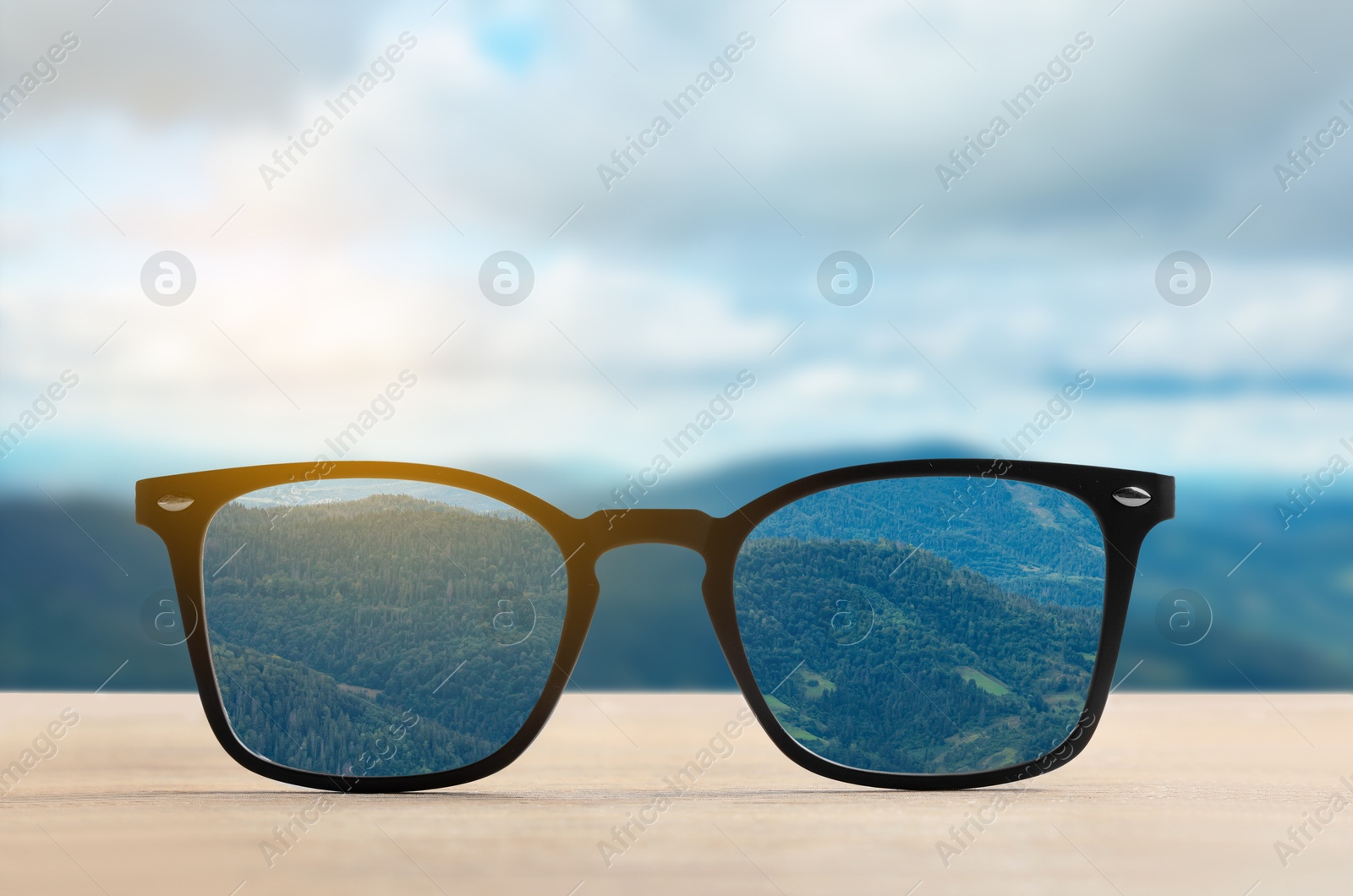 Image of Glasses against beautiful landscape. View through lenses more clear. Vision correction