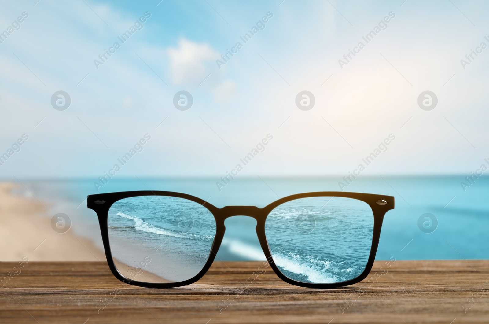 Image of Glasses against seascape. View through lenses more clear. Vision correction