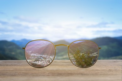 Image of Glasses against beautiful landscape. View through lenses more clear. Vision correction