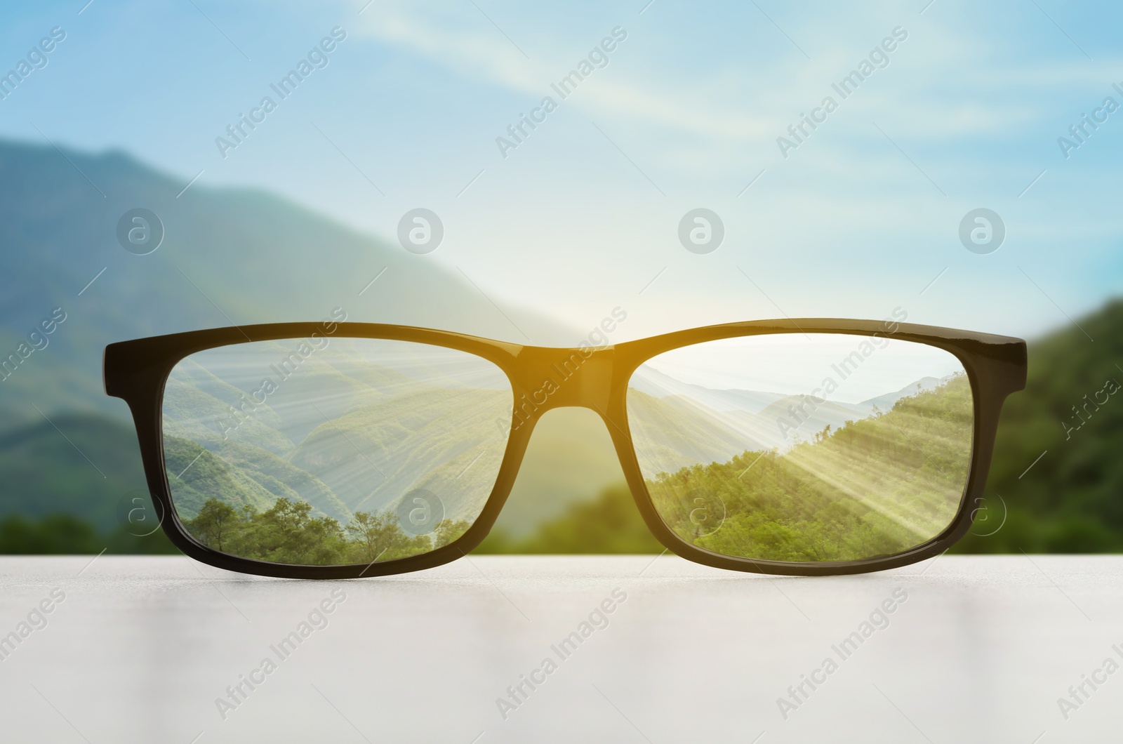 Image of Glasses against beautiful landscape. View through lenses more clear. Vision correction