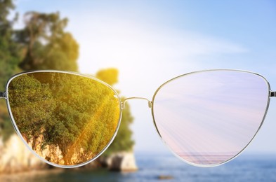 Image of Glasses against beautiful landscape. View through lenses more clear. Vision correction