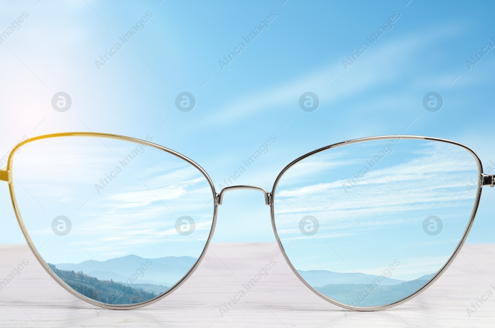 Image of Glasses against beautiful landscape. View through lenses more clear. Vision correction