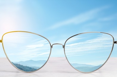 Image of Glasses against beautiful landscape. View through lenses more clear. Vision correction