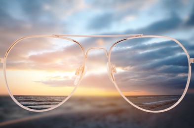 Image of Glasses against seascape. View through lenses more clear. Vision correction