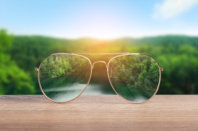 Image of Glasses against beautiful landscape. View through lenses more clear. Vision correction